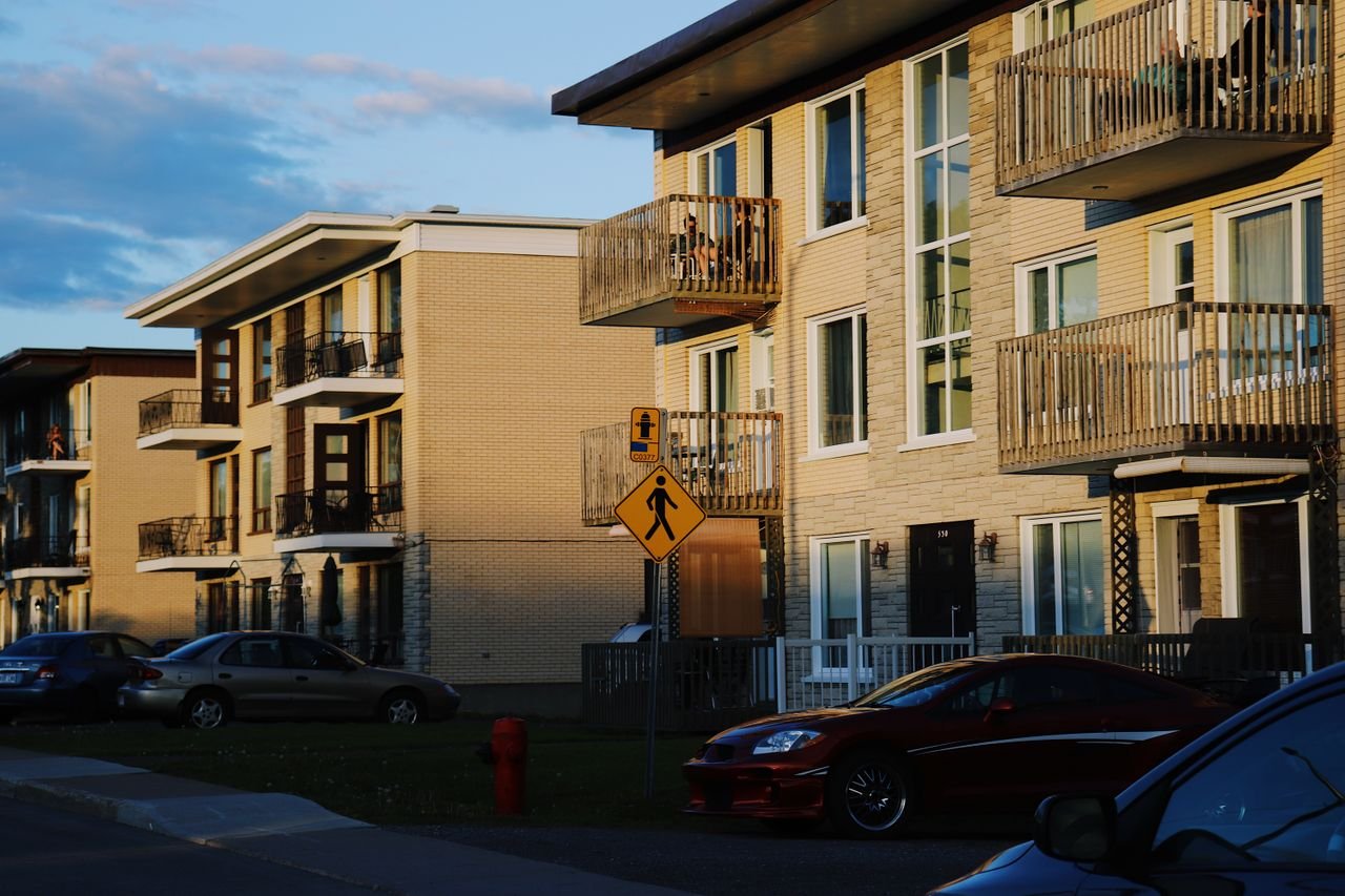 Crafting Captivating Headlines: Your awesome post title goes here Charming residential buildings in Québec City, captured during a vibrant sunset glow, with cars and street scenery.
